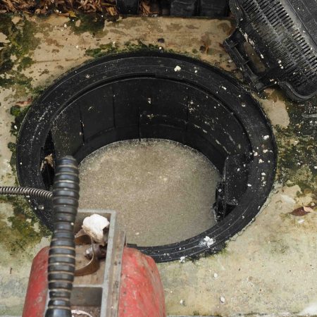 Drain Cleaning. Plumber Repairing Clogged Grease Trap With Auger
